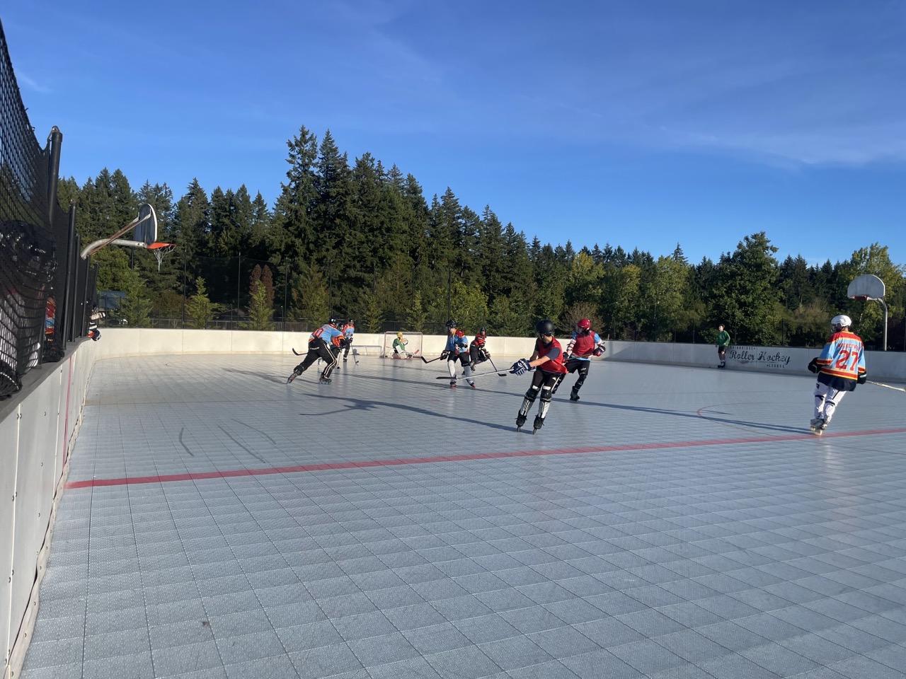 Community inline hockey game on an outdoor rink